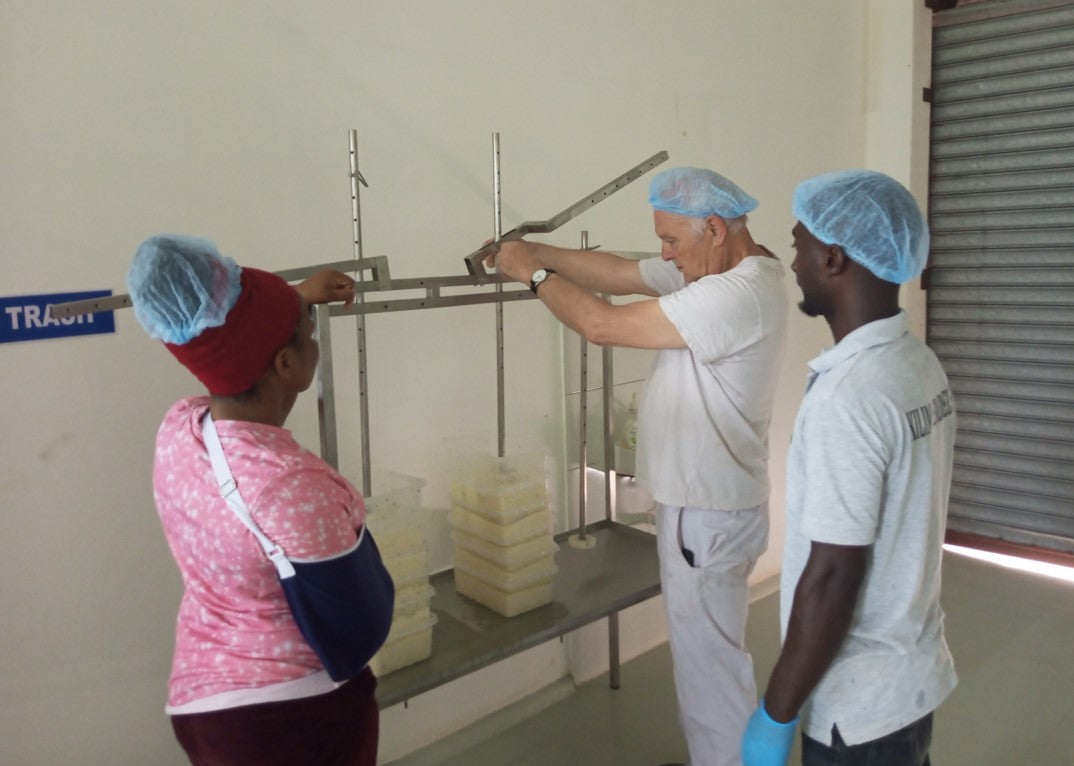 Georg showing two staff member how to process cheese
